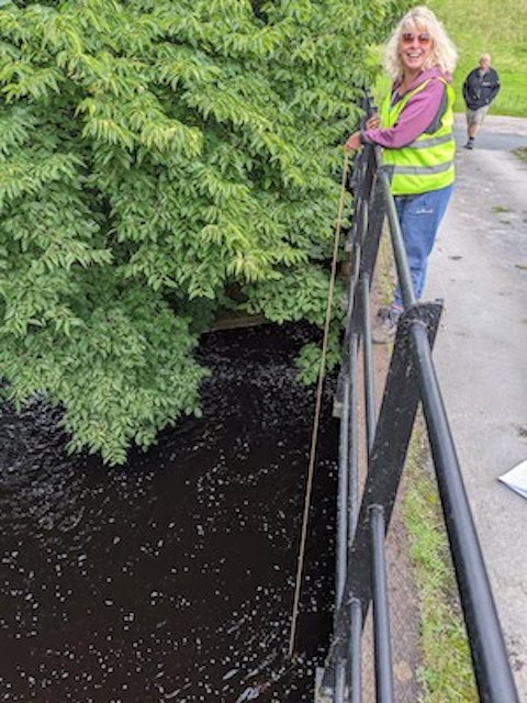 Low Sikes. Halfway between Lofthouse and Ramsgill, this bridge, links the main road to West House Farm. Clear water. Karen from Team 2 is sampling from the bridge
