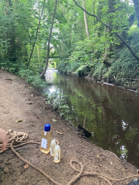 Waterside car park. Below the bridge, above the island. above a visible pipe.